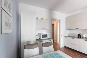 eine Küche mit weißen Schränken und einer Mikrowelle in der Unterkunft A Balcony on Lake Maggiore in Belgirate