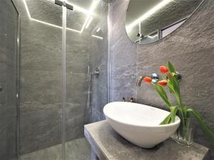 La salle de bains est pourvue d'un lavabo et d'une douche en verre. dans l'établissement Gawra Apartament Studio, à Zakopane