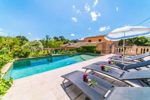 a swimming pool with lounge chairs and an umbrella at Ideal Property Mallorca - Can Roig Gran in Pollença
