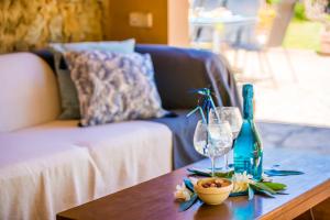 a coffee table with a bottle and glasses on it at Ideal Property Mallorca - Can Roig Gran in Pollença