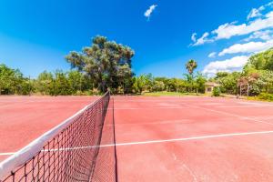 una pista de tenis con una red en Ideal Property Mallorca - Can Roig Gran, en Pollensa