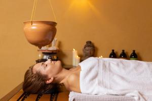 a woman laying on a bed in a room at Hotel Caesius Thermae & Spa Resort in Bardolino