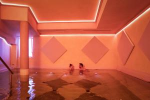 two dogs are sitting in a pool of water in a room at Hotel Caesius Thermae & Spa Resort in Bardolino