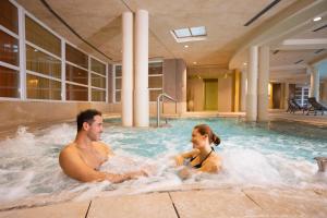 a man and a woman sitting in a hot tub at Hotel Caesius Thermae & Spa Resort in Bardolino