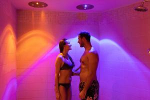 a man and a woman standing in a purple room at Hotel Caesius Thermae & Spa Resort in Bardolino