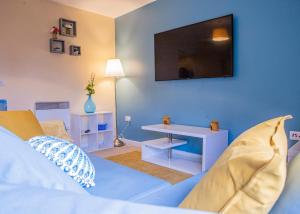 a blue room with a bed and a tv on the wall at Broad gauge way in Wolverhampton