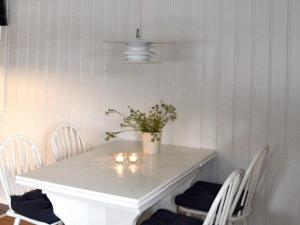 een witte tafel met stoelen en een vaas met bloemen erop bij Holiday home Utvik IV in Utvik