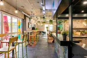 a restaurant with a bar with colorful chairs and tables at Ekho Hotel Grenoble Nord Saint Egrève in Saint-Égrève +47 photos