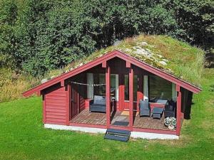 a red cabin with a grassy roof on a field at 6 person holiday home in olden-By Traum in Olden +16 photos