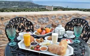 - une table avec un plateau de produits pour le petit-déjeuner et des boissons dans l'établissement Lithos Stone Suites, à Areópoli