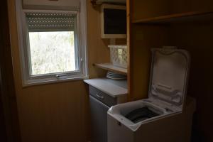 a small kitchen with a washing machine and a window at Montesquiou-Chalet-5 personnes in Montesquiou