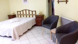 a bedroom with a bed and two chairs at Studio charmant à Sarlat-la-Canéda avec terrasse in Sarlat-la-Canéda