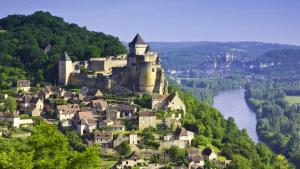 a castle on top of a hill next to a river at Studio charmant à Sarlat-la-Canéda avec terrasse in Sarlat-la-Canéda
