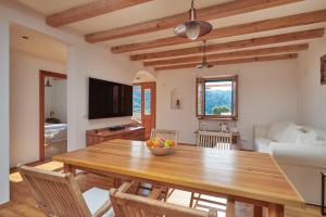 eine Küche und ein Wohnzimmer mit einem Holztisch in der Unterkunft Park Cottage in Goveđari