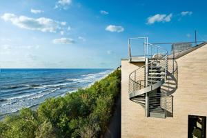 een trap aan de zijkant van een gebouw naast de oceaan bij Boulevard Ustronie Morskie by Zdrojowa in Ustronie Morskie