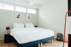 um quarto com uma cama grande e lençóis brancos em Edgar Suites Montmartre - Abbesses em Paris