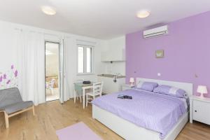 1 dormitorio con cama morada y mesa en Apartments Villa Karmen en Dubrovnik