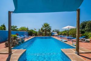 una piscina con sillas y sombrilla en Ideal Property Mallorca - Sort en Inca