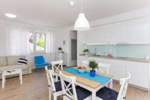 Apartments Villa Karmen في دوبروفنيك: مطبخ وغرفة معيشة مع طاولة وكراسي