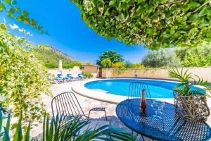 una mesa y sillas junto a una piscina en Sort Llarga en Pollença