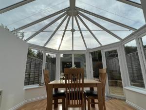 a conservatory with a table and chairs and a glass ceiling at Cotswold apartment with private parking! in Stow on the Wold