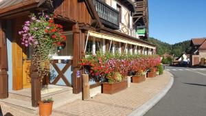una fila di fiori sul lato di un edificio di Hotel Restaurant La Petite Auberge Alsace a Le Hohwald
