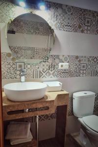 a bathroom with a sink and a toilet and a mirror at Hacienda Sajorami in Zahora