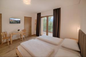 una camera con un grande letto e un tavolo con un tavolo di Appartments Lindenhof a Riscone