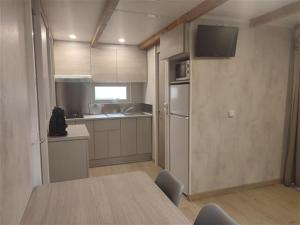 a kitchen with a refrigerator, stove, microwave and a table at Camping-Bungalows Altomira in Navajas