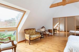 una camera da letto mansardata con ampia finestra e mobili di Grande maison familiale à 230m de la plage ! a Planguenoual