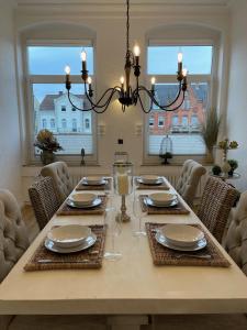 a dining room table with chairs and a chandelier at Ferienwohnung Brückenkopf OG in Hameln +21 photos