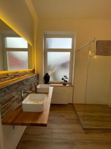 a bathroom with two sinks and a window at Ferienwohnung Brückenkopf OG in Hameln