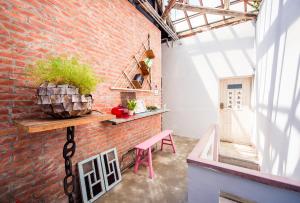 a brick wall with a table and a pink chair at H& tainan weshare hotel in Tainan