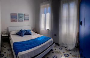 a bedroom with a bed with blue pillows on it at Nido del Sole Ischia in Ischia