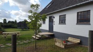 a white house with a picnic table and a bench at Elleholm A in Odense