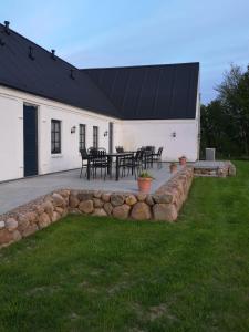 une terrasse avec un toit noir, une table et des chaises dans l'établissement Bøgehus, à Vejle