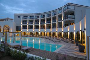 un hotel con piscina di fronte a un edificio di Eco-Résidence Dolce Paese a Algajola