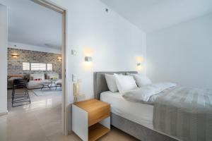 a bedroom with a bed and a living room at Relaxing 2 BR Apt w Parking Near Nahalat Binyamin by Sea N' Rent in Tel Aviv