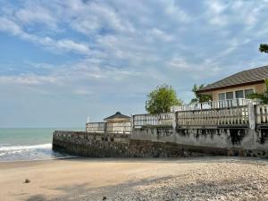 a house on the beach next to the ocean at RIM Chaam By RoomQuest in Cha Am