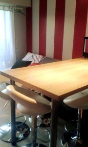 un tavolo in legno con sedie e un letto in una camera di Appartement d'une chambre avec jardin a Houlgate a 2 km de la plage a Houlgate