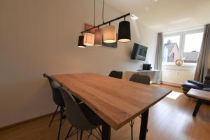 una sala da pranzo con tavolo e sedie in legno di FeWo "Sandburg" Whg 36 a Kellenhusen