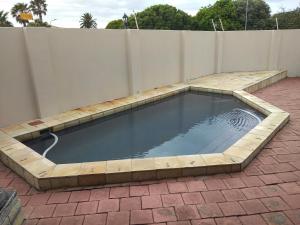 einen Pool auf einer Terrasse mit einem Zaun in der Unterkunft Winchester Place in Port Elizabeth