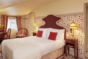 a bedroom with a large white bed with red pillows at InterContinental Bordeaux Le Grand Hotel, an IHG Hotel in Bordeaux