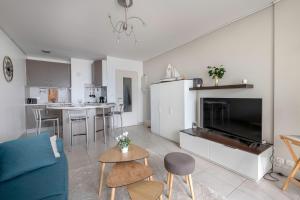 sala de estar con sofá azul y cocina en Magnifique vue mer pour un sejour Baulois, en La Baule