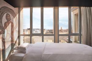 a bedroom with a bed and a large window at InterContinental Bordeaux Le Grand Hotel, an IHG Hotel in Bordeaux