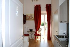 a kitchen with red curtains and a table at Piccolo Navy in Livorno