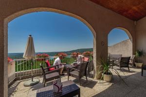 two people sitting at a table on a balcony at Belambra Clubs Montpezat - Le Verdon in Montagnac +16 photos