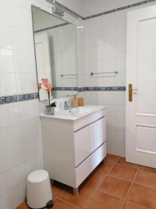 y baño con lavabo blanco y espejo. en Apartamento Riomar, en Vila Nova de Milfontes