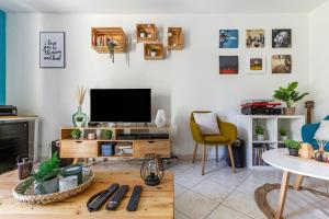 sala de estar con TV y mesa en L'anisé, en Metz