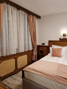 um quarto com uma cama e uma janela em Chuchura Family Hotel em Koprivshtitsa